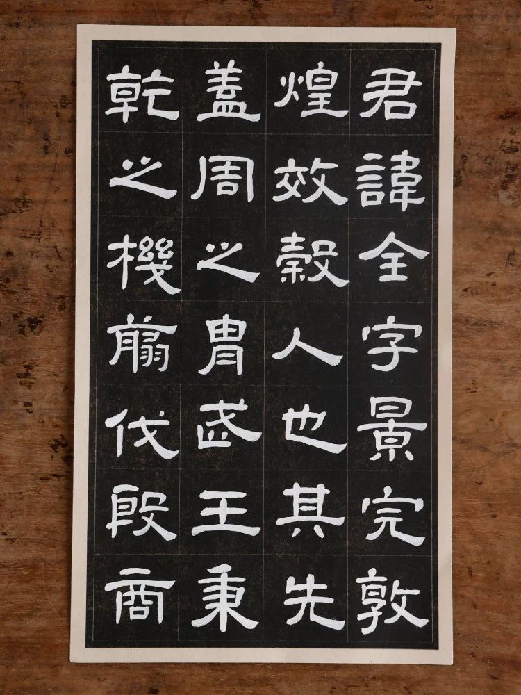 White Chinese calligraphy characters arranged in a square grid on black paper with a cream border