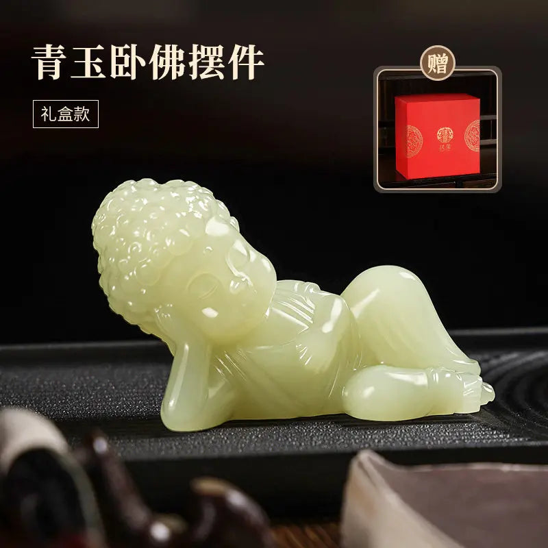 A light green jade Buddha reclining figurine displayed on a dark surface, with Chinese text in the upper left and a small inset showing a red gift box.