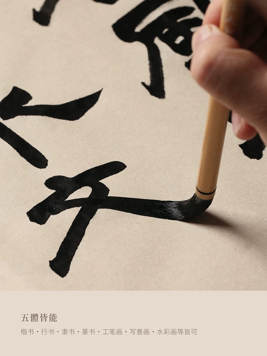 Hand using a Wen Xin Tang Bai Yun brush to write Chinese calligraphy with black ink on paper
