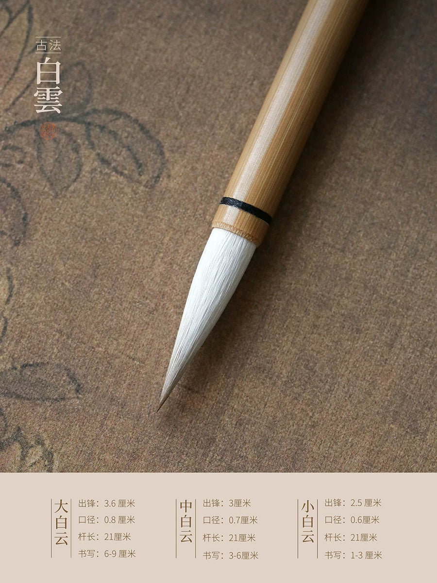 Close-up of the pointed white mixed-hair tip and bamboo handle of a Wen Xin Tang Bai Yun calligraphy brush